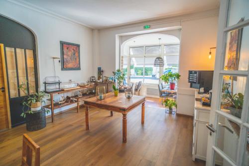 Una sala de estar con una mesa y una cocina. en Hôtel Le Saint Pierre - Demeures & Châteaux , La Baule-Escoublac, en La Baule