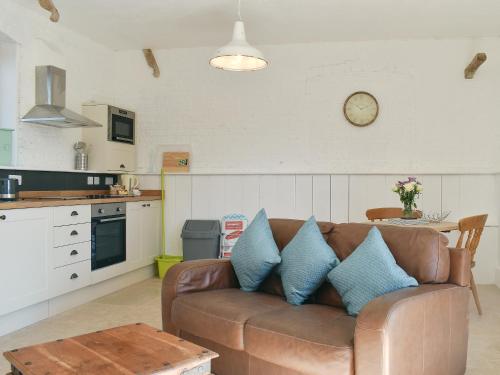 a living room with a brown couch with blue pillows at The Nags Stable - Ukc4136 in Arlingham