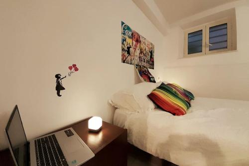 1 dormitorio con 1 cama y escritorio con ordenador portátil en One Love Vicino AUTOSTRADA 40 MIN ROMA, en Orte