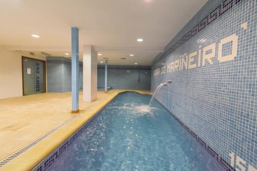 a swimming pool with water coming out of a wall at Hotel Alda Fogar do Mariñeiro in Ribadeo