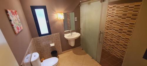 a bathroom with a white toilet and a sink at Luxury holiday villas in Bahrain for Families in Bārbār
