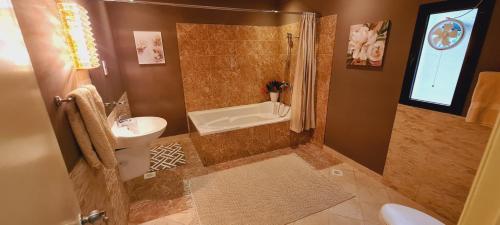 uma casa de banho com um chuveiro, um lavatório e um WC. em Luxury holiday villas in Bahrain for Families em Bārbār