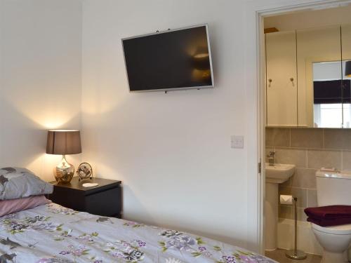 a bedroom with a bed and a television on the wall at Shepley Mews in Glossop