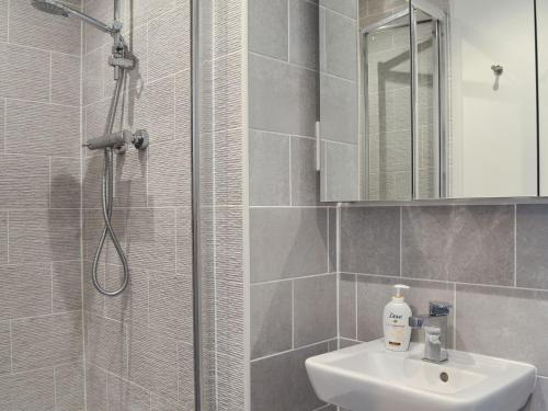 een badkamer met een douche, een wastafel en een spiegel bij Shepley Mews in Glossop