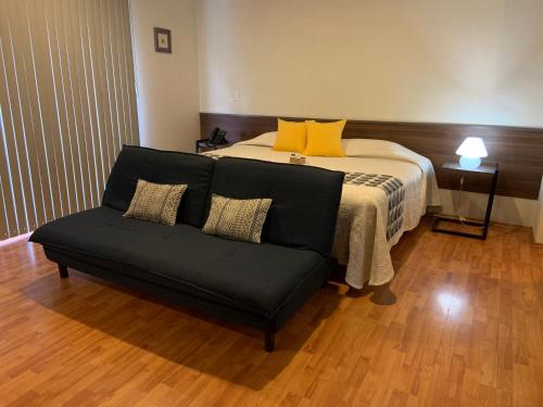 a bedroom with a bed and a couch in front of it at Star Suites México in Mexico City