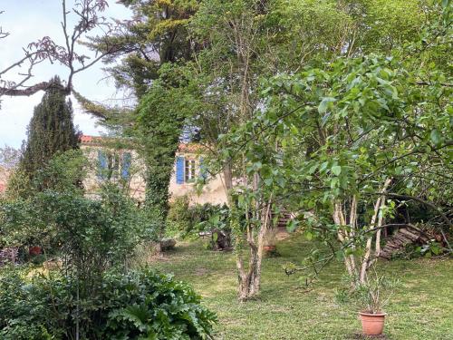 a garden with trees and a house in the background at La Bonne Rade in Curzon