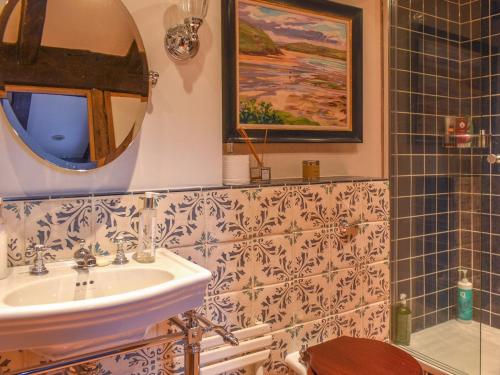 a bathroom with a sink and a mirror at Chapel Cottage, in Holmbury Saint Mary