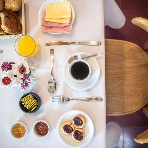 a breakfast table with a cup of coffee and pastries at Bella Tilcara Boutique Hotel in Tilcara