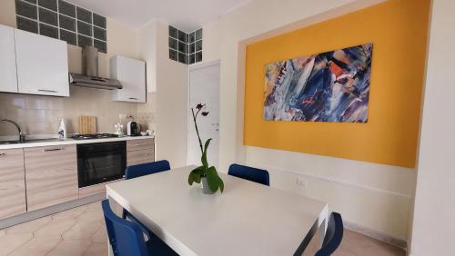 uma cozinha com uma mesa branca e cadeiras azuis em Marifra Flats em Taormina