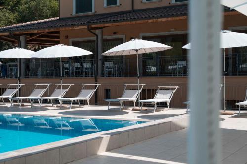a group of chairs and umbrellas next to a swimming pool at Grand Hotel Elite in Cascia