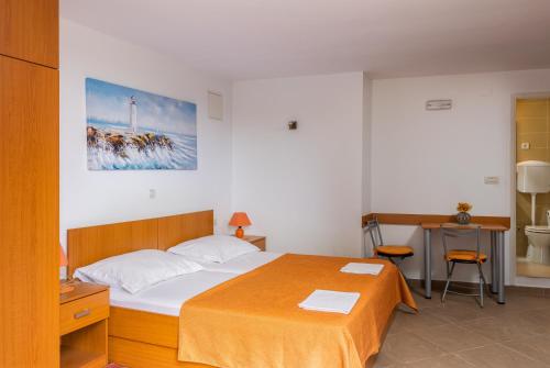 Cette chambre comprend un lit, un bureau et une table. dans l'établissement Studio and Room Lena, à Dubrovnik