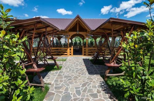 a pavilion at a resort with a stone walkway at Pensiunea Royal in Borşa