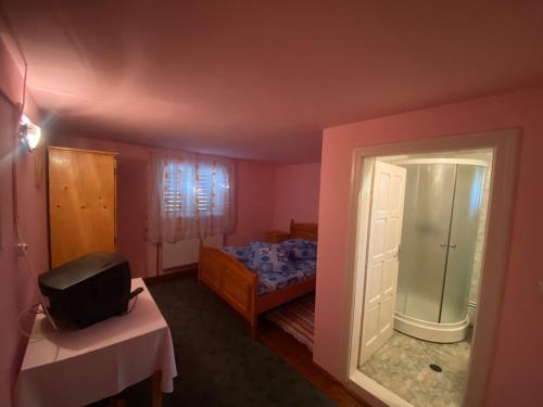 Dormitorio pequeño con cama y espejo en Cabana Corina, en Vartop