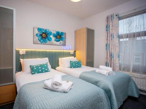 duas camas num quarto com toalhas em Freville Cottage em Shildon