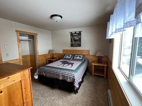 a bedroom with a bed and a window at Faithful Street Inn in West Yellowstone