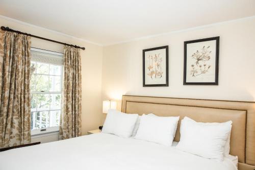 a bedroom with a white bed and a window at Three Village Inn in Stony Brook