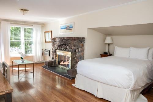 a bedroom with a large bed and a fireplace at Three Village Inn in Stony Brook