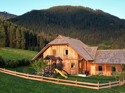 a large wooden house with a slide in front of it at Nagerhof in Gnesau