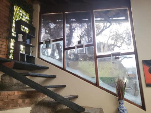 a room with three windows and a staircase in front at ALBATROSSWAYS LODGE in Sandton