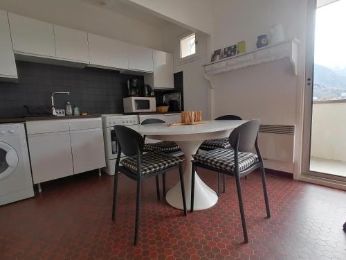 une cuisine avec une table et des chaises dans une cuisine dans l'établissement Impasse des Rhododendrons, Résidence 