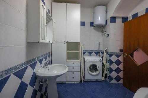a bathroom with a sink and a washing machine at Salvanna Centro Storico in Naples