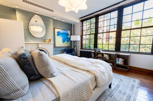 a bedroom with a large bed and large windows at E10-3 3BR Designer Townhouse in New York