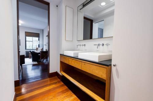 uma casa de banho com 2 lavatórios e um espelho em E10-3 3BR Designer Townhouse em Nova York
