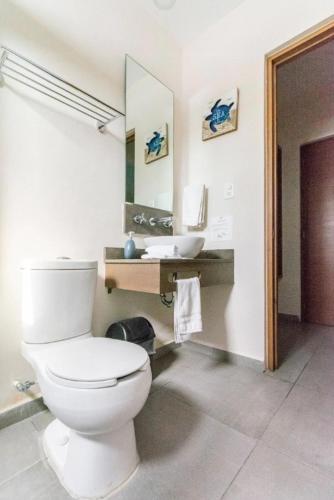 a bathroom with a white toilet and a sink at Viento Suites Cancún in Cancún