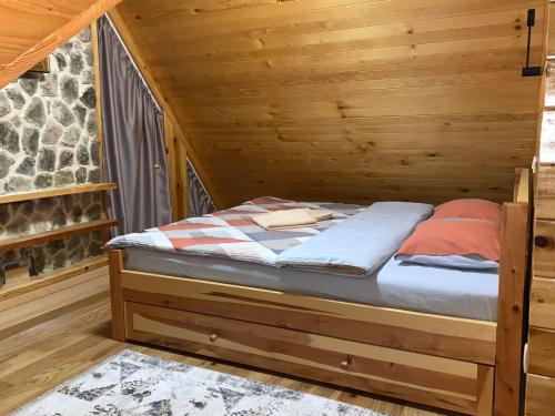 1 cama en una habitación de madera en una cabaña en Alpine House, en Žabljak