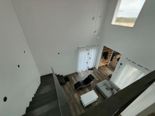 une vue de tête sur un salon avec un escalier dans l'établissement Villa d'architecte à 8 min de l'Ile de Ré, à LʼHoumeau