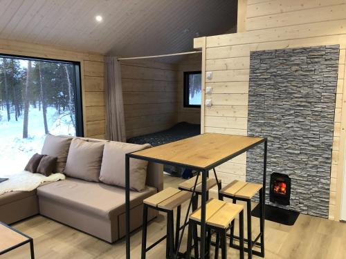 a room with a couch and a table and a fireplace at Chalet Luokta in Inari