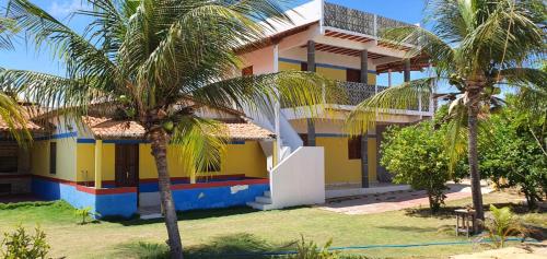 ein Haus mit Palmen davor in der Unterkunft Dunas Bar&Hotel in Canoa Quebrada