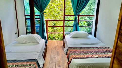 2 camas en una habitación con ventana en Cabaña The Sunset, en Santa Marta