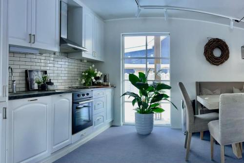a kitchen with white cabinets and a table with a plant at New apartment near the lifts tourist center Trysil in Trysil