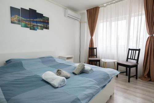 a bedroom with a blue bed with two pillows at Garsoniera 2 Mega Mall in Bucharest