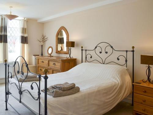 a bedroom with a bed and a chair and a mirror at Old Church School in Plympton