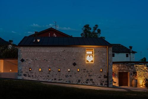 een stenen gebouw met een klok aan de zijkant bij Agrialloggio Antica Gastaldia 