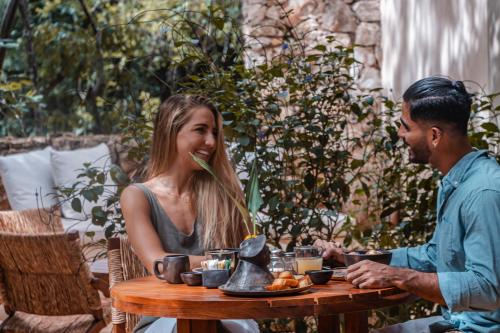 a man and a woman sitting at a table at Oriundo Luxury Nature Villas in Valladolid