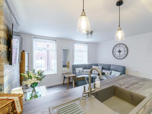 a kitchen with a sink and a living room at Kays in Cleveleys