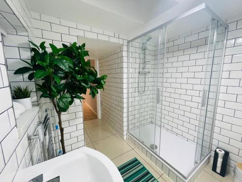 a bathroom with a shower and a toilet and a plant at Bristol City Stays - Harbourside Apartments in Bristol