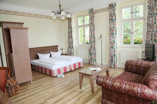 ein Hotelzimmer mit einem Bett und einem Sofa in der Unterkunft Hotel Goldener Adler Garni in Hallstadt