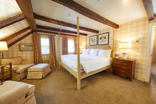 a bedroom with a bed and a living room with a couch at Three Village Inn in Stony Brook