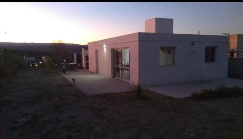 una pequeña casa rosa con una puesta de sol en el fondo en Casa de campo in 