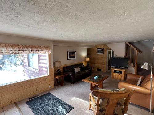 a living room with a couch and a tv at Faithful Street Inn in West Yellowstone