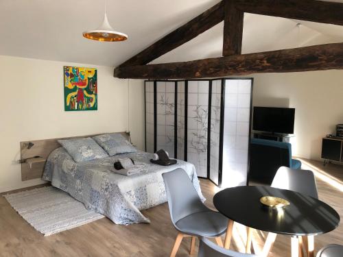 une chambre avec un lit, une table et des chaises dans l'établissement La Pignotte, à Avignon