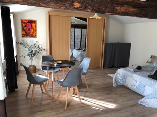 une pièce avec une table, des chaises et un lit dans l'établissement La Pignotte, à Avignon