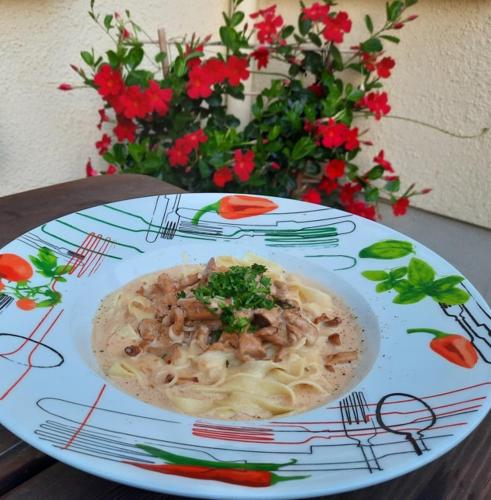 a plate with a bowl of food on a table with flowers at Reiterhof Schmidt, Gaststätte & Pension in Golk