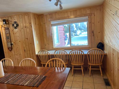 a dining room with a table and chairs and a window at Faithful Street Inn in West Yellowstone