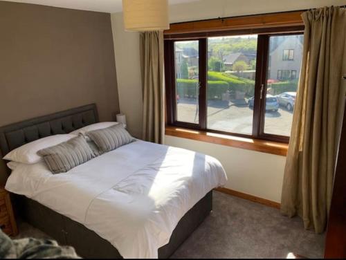 a bedroom with a bed and a large window at Stornoway Holiday Let in Stornoway