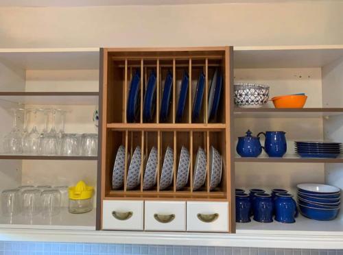 a cabinet filled with blue vases and bowls at Stornoway Holiday Let in Stornoway